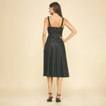 Woman wearing a black dress against a beige background