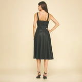 Woman wearing a black dress against a beige background