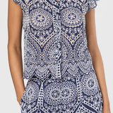 Navy and white patterned top with ruffled sleeves on a plain background