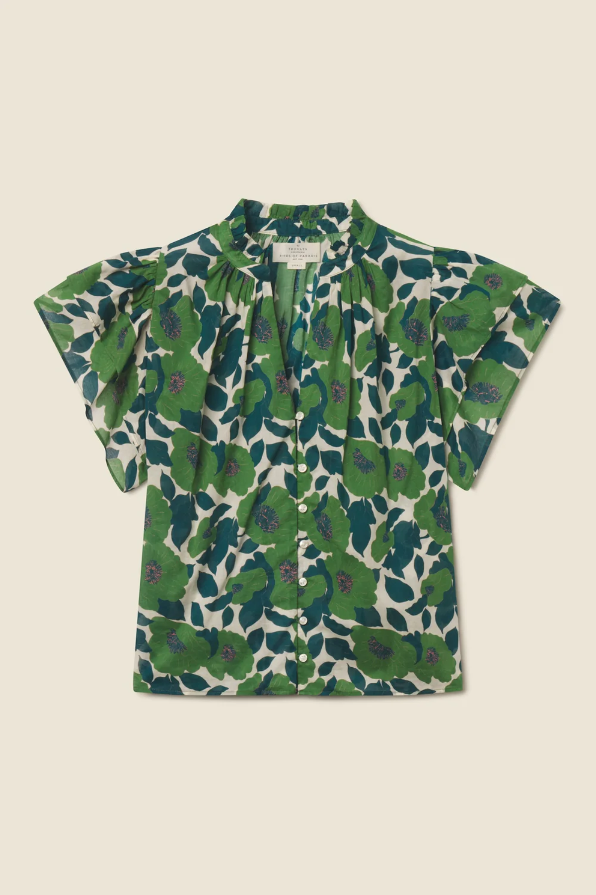 green floral blouse on tan background 