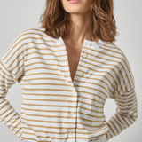 Woman wearing a yellow and white striped shirt against a plain background