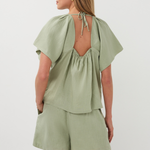 Woman wearing a green outfit with a plain background
