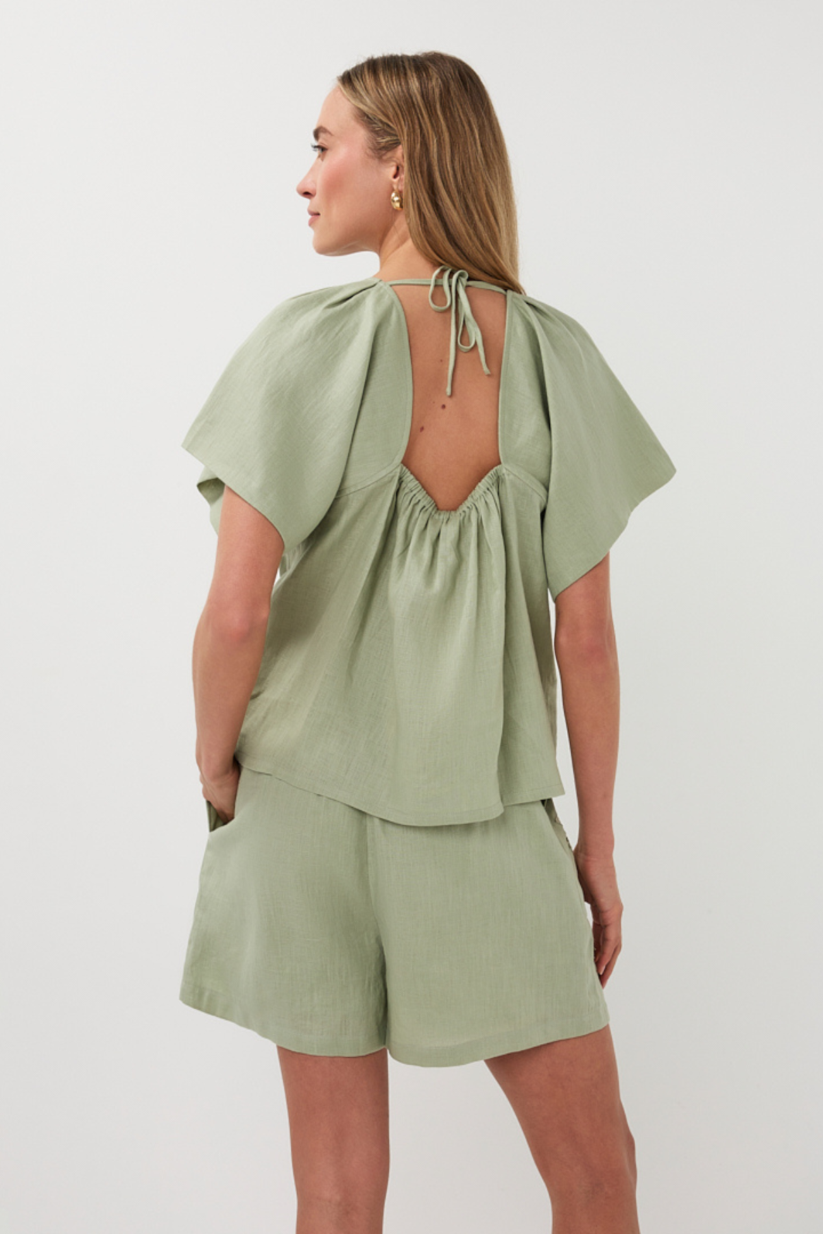 Woman wearing a green outfit with a plain background