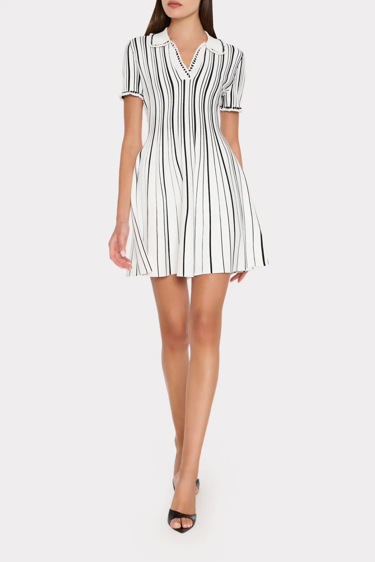 Woman wearing a black and white striped dress on a white background