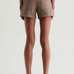 Person wearing brown shorts on a white background