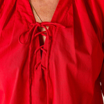 Red blouse with a tie neckline on a plain background