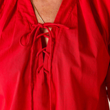 Red blouse with a tie neckline on a plain background