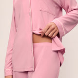 Person wearing a pink pajama set on a plain background