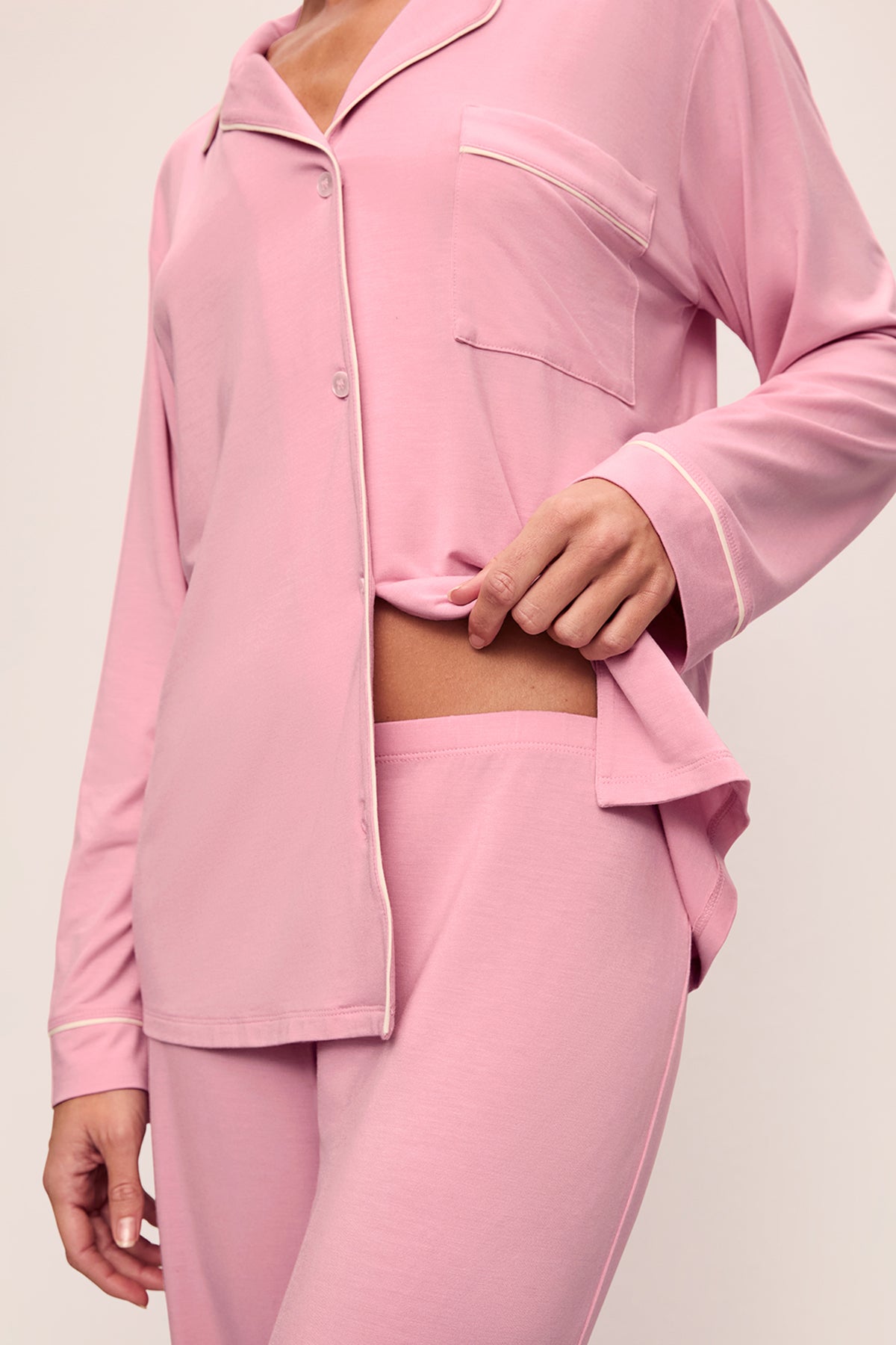 Person wearing a pink pajama set on a plain background