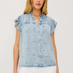 Woman wearing a light blue denim top with ruffled sleeves on a white background