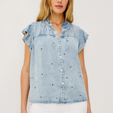 Woman wearing a light blue denim top with ruffled sleeves on a white background