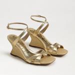 Gold wedge sandals on a white background
