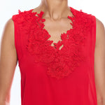 Red sleeveless top with floral lace details on a white background