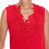 Red sleeveless top with floral lace details on a white background