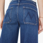 Blue jeans worn by a person on a white background