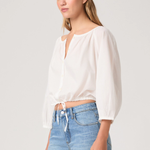 Woman wearing a white blouse and blue jeans on a plain background