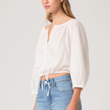 Woman wearing a white blouse and blue jeans on a plain background