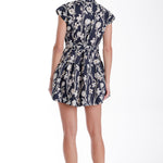 Embroidered mini dress with refined detailing, styled with neutral accessories