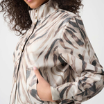 Woman wearing a camouflage-patterned jacket on a white background