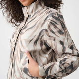 Woman wearing a camouflage-patterned jacket on a white background