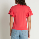 Person wearing a red t-shirt and blue jeans against a plain background