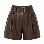 A pair of high-waisted brown faux-leather shorts with pleated side details, a matching belt, and a gold-tone buckle, shown on a plain white background.