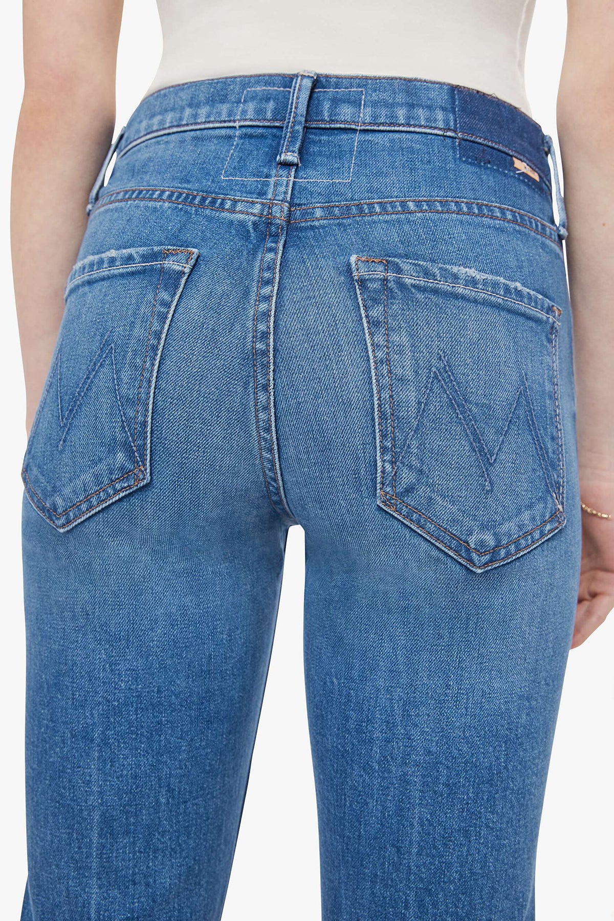 Woman wearing mid-wash cropped flare jeans with a slim upper fit and subtle kick-flare hem.