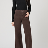 Person wearing brown wide-leg pants and a black top on a white background