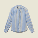 A light blue long-sleeve button-up shirt with vertical white stripes, featuring a high collar and buttoned front, laid flat against a solid beige background.