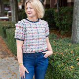 Tweed top with a structured silhouette in neutral tones.