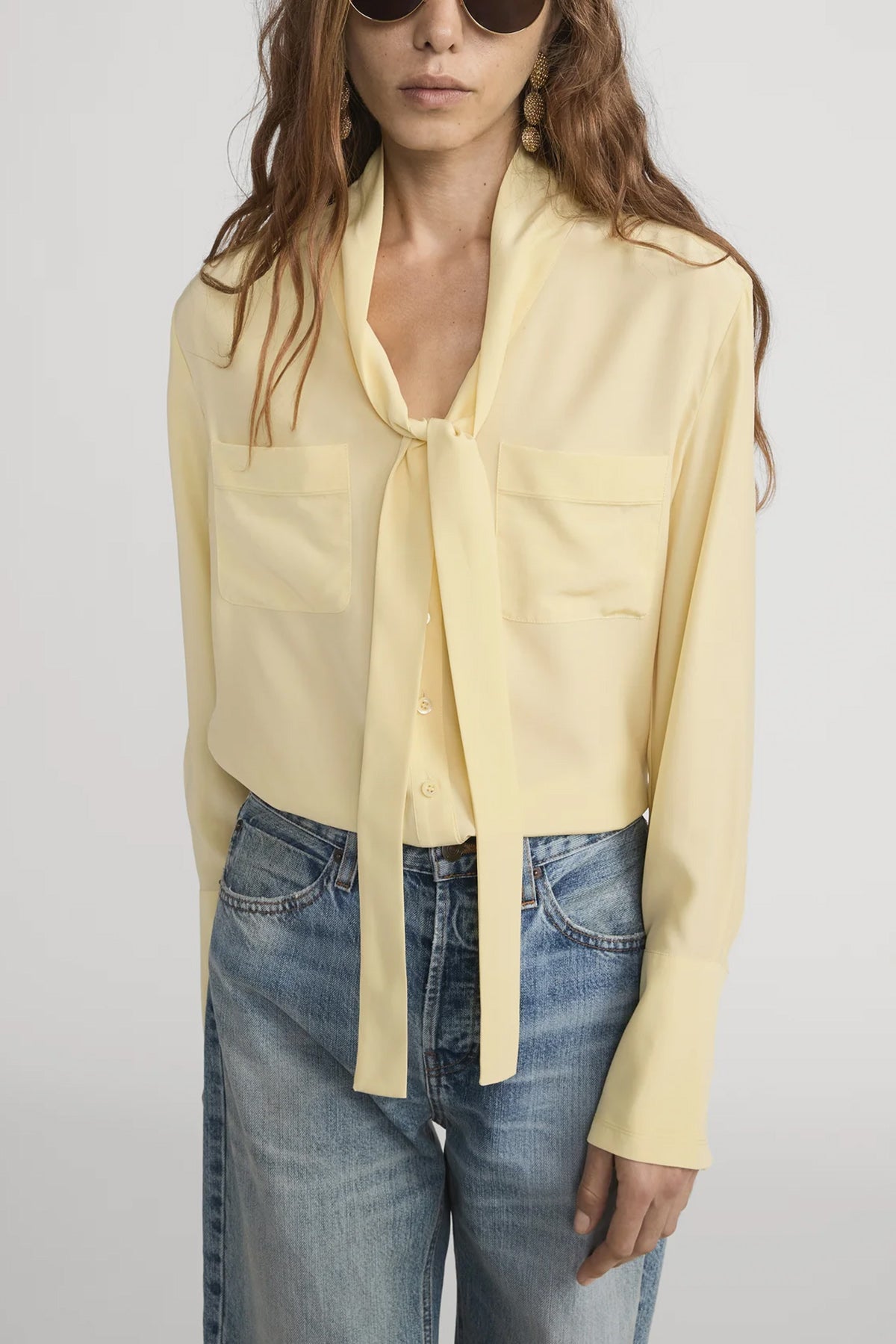Silk blouse with a modern tie neckline, styled with denim