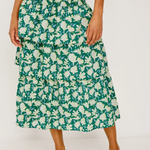 Person wearing a green floral skirt on a white background