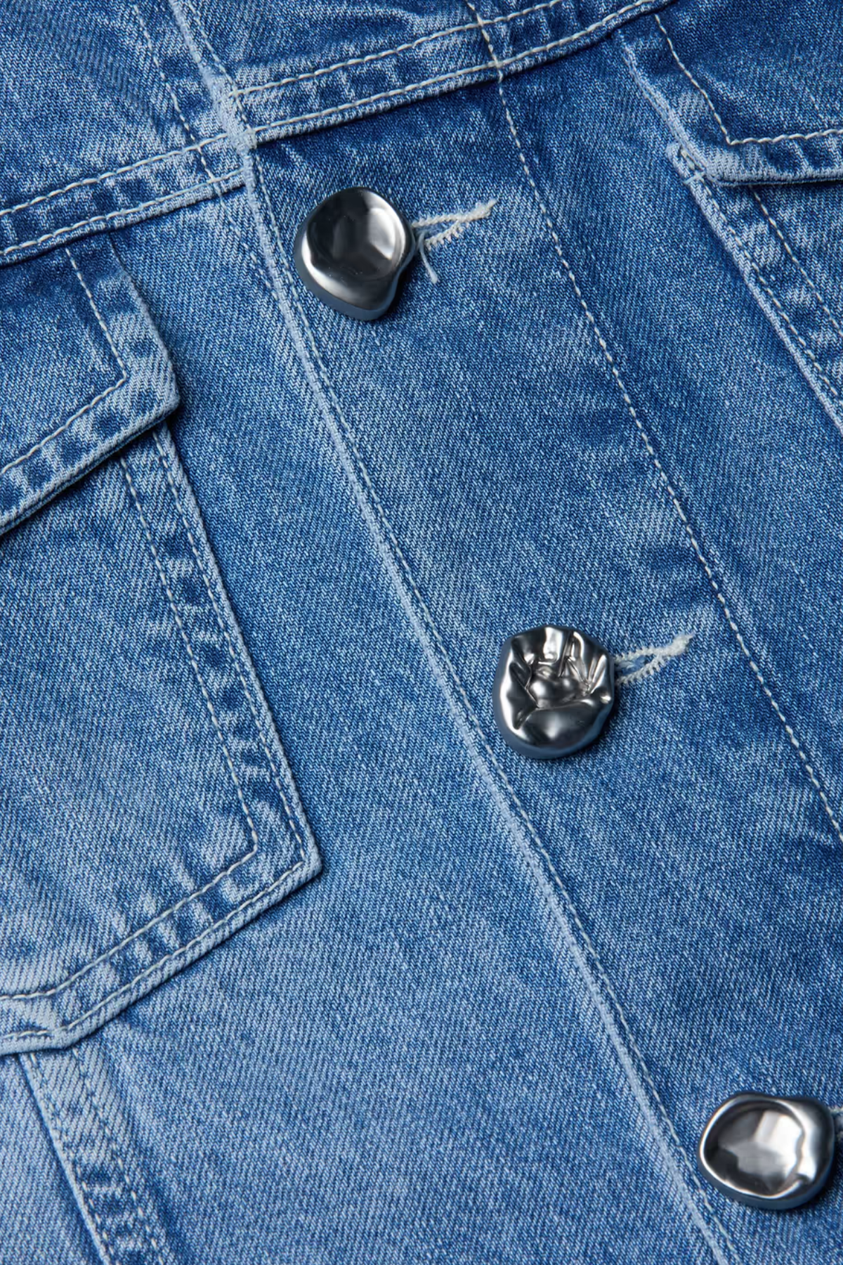 Close-up of blue denim fabric with buttons