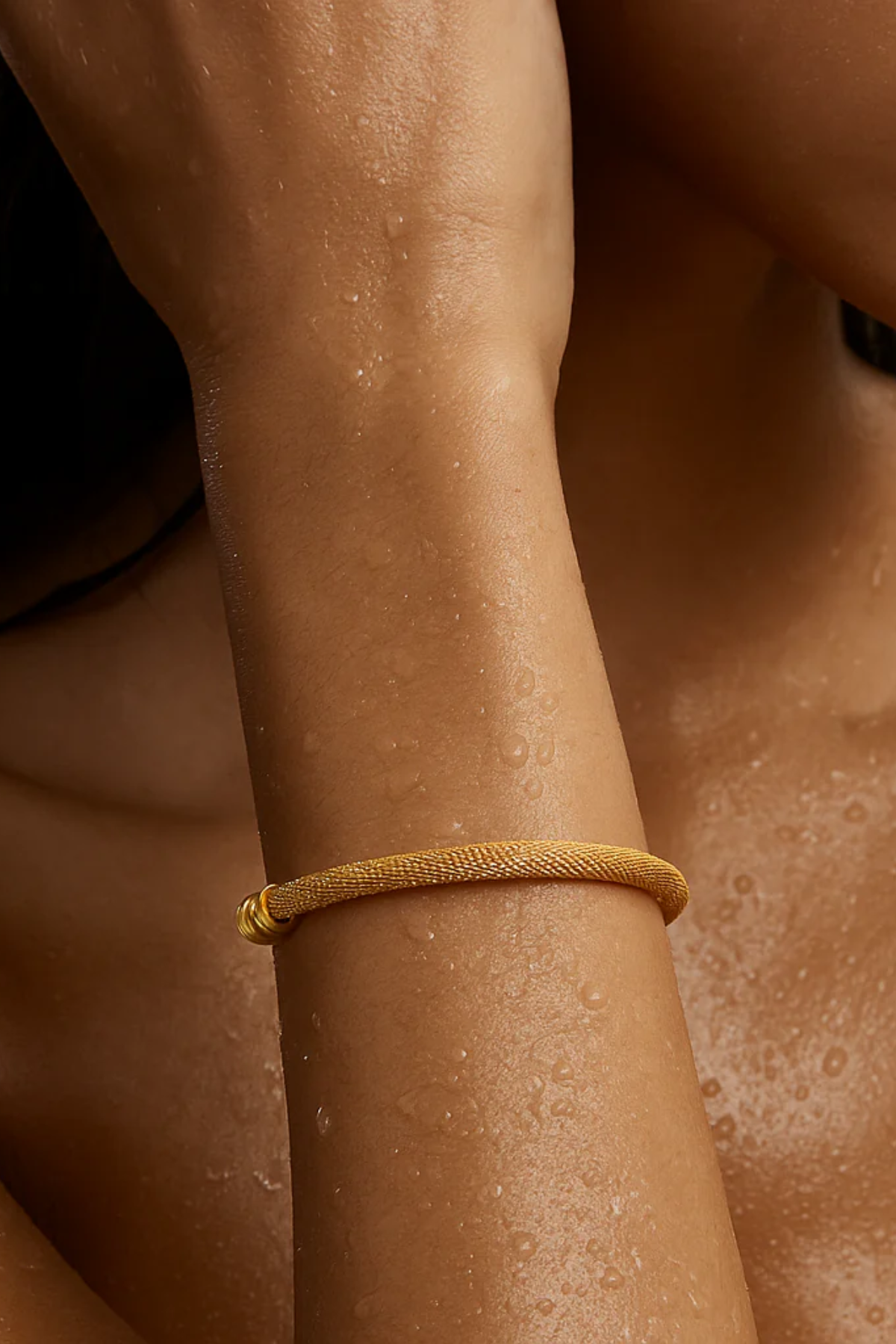 Gold bracelet on a person's wrist with a blurred background