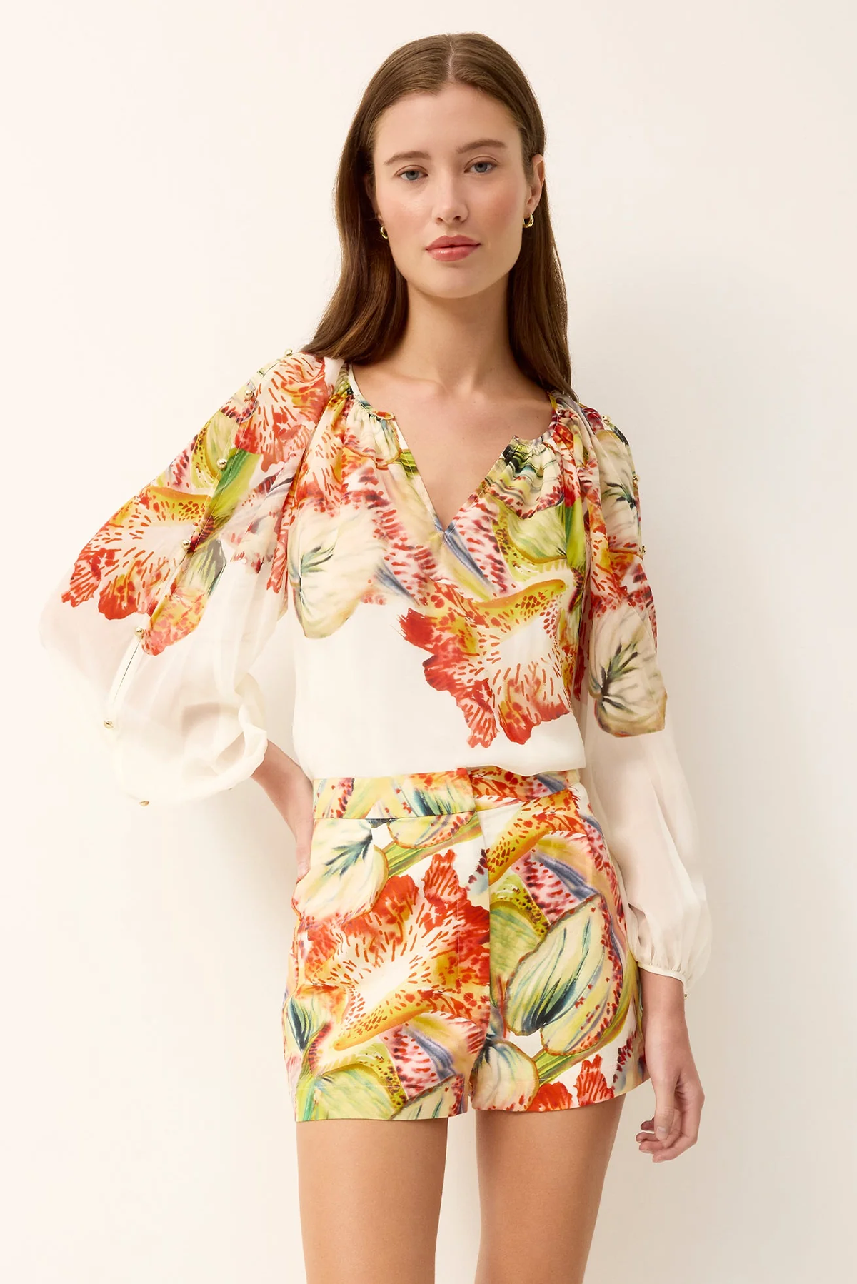 woman in printed blouse and shorts on white background 