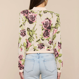 Person wearing a floral cardigan with a beige background