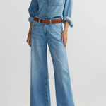 Model wearing medium-wash low-rise baggy wide-leg denim jeans.