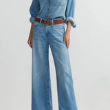 Model wearing medium-wash low-rise baggy wide-leg denim jeans.
