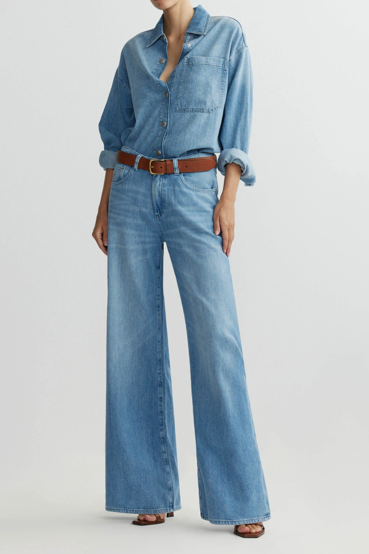 Model wearing medium-wash low-rise baggy wide-leg denim jeans.