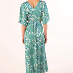 Woman wearing a green patterned dress on a white background