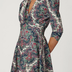 Woman wearing a patterned dress with a plain background