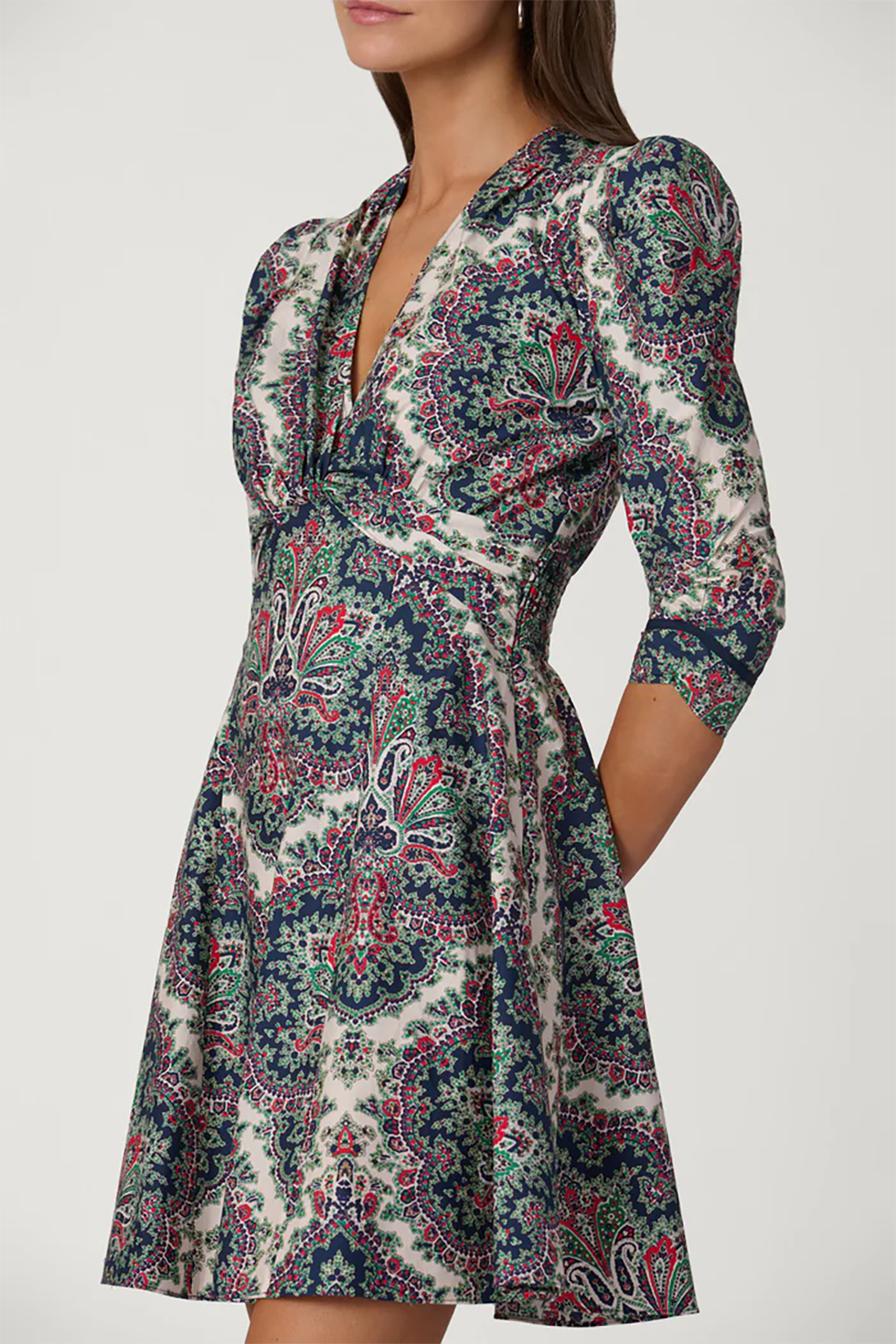 Woman wearing a patterned dress with a plain background