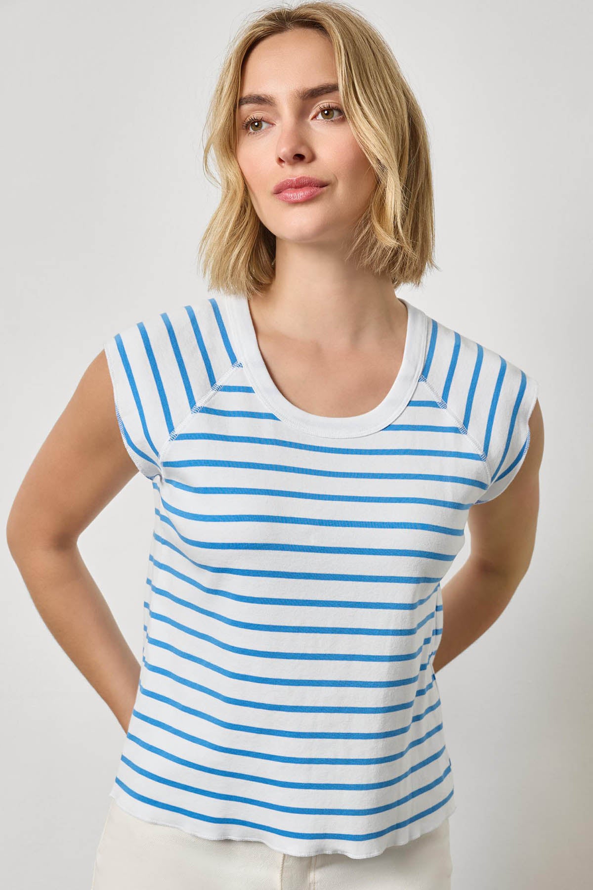 Woman wearing a blue and white striped shirt against a plain background