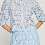 Light blue lace dress worn by a model on a plain background