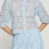 Light blue lace dress worn by a model on a plain background