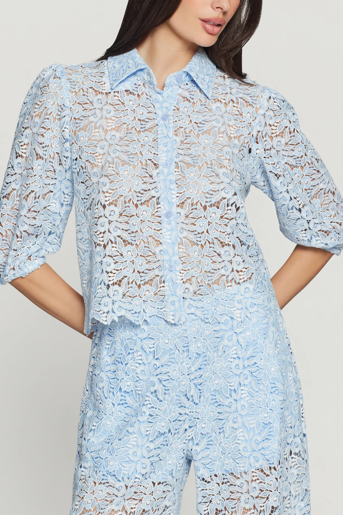 Light blue lace dress worn by a model on a plain background