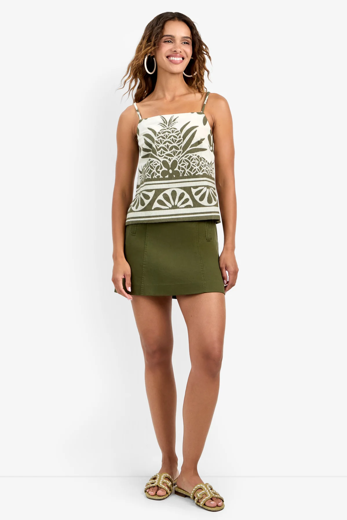 Model wearing a fitted patterned skirt styled with a coordinating sleeveless top for a polished look.