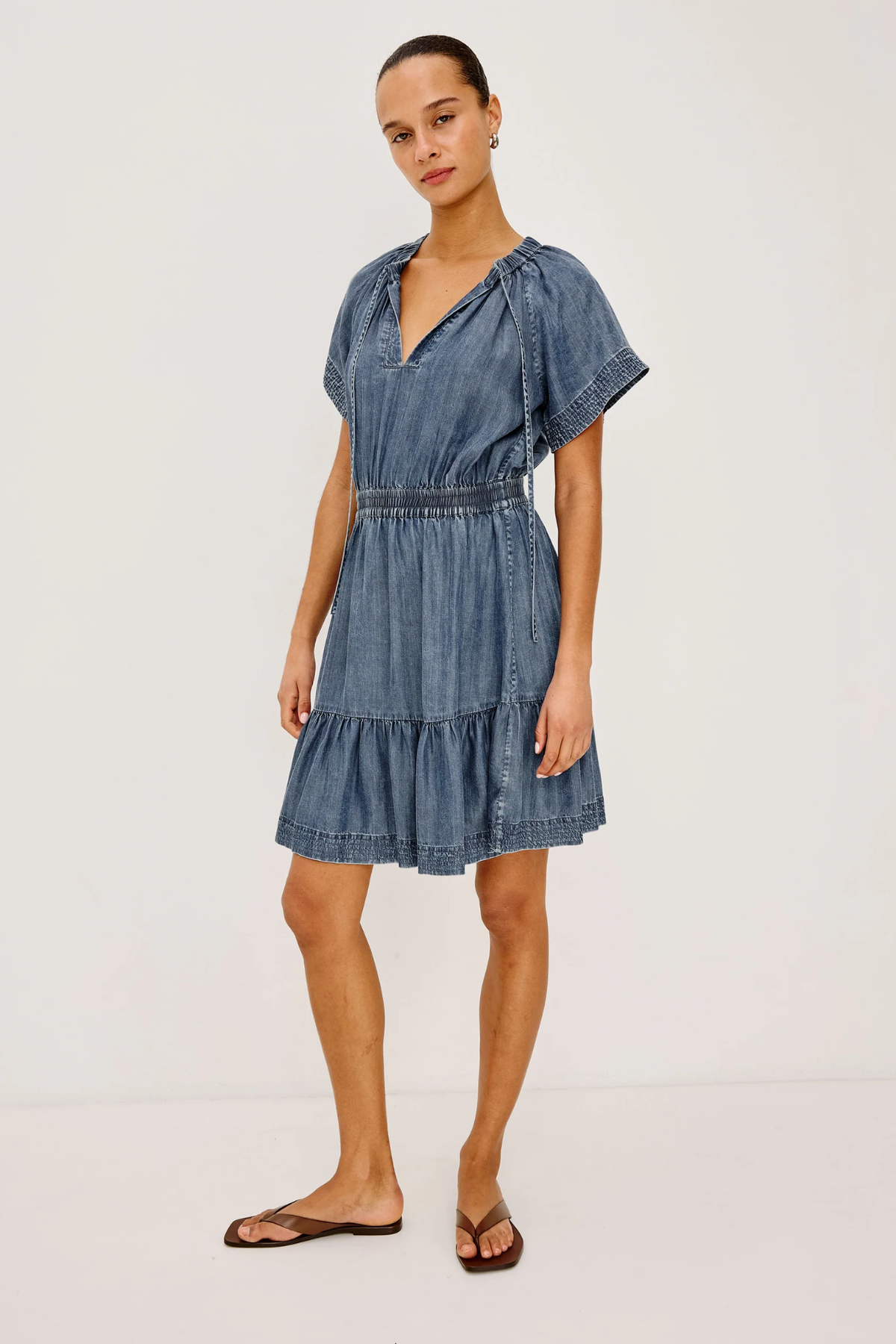 Woman wearing a denim dress on a white background