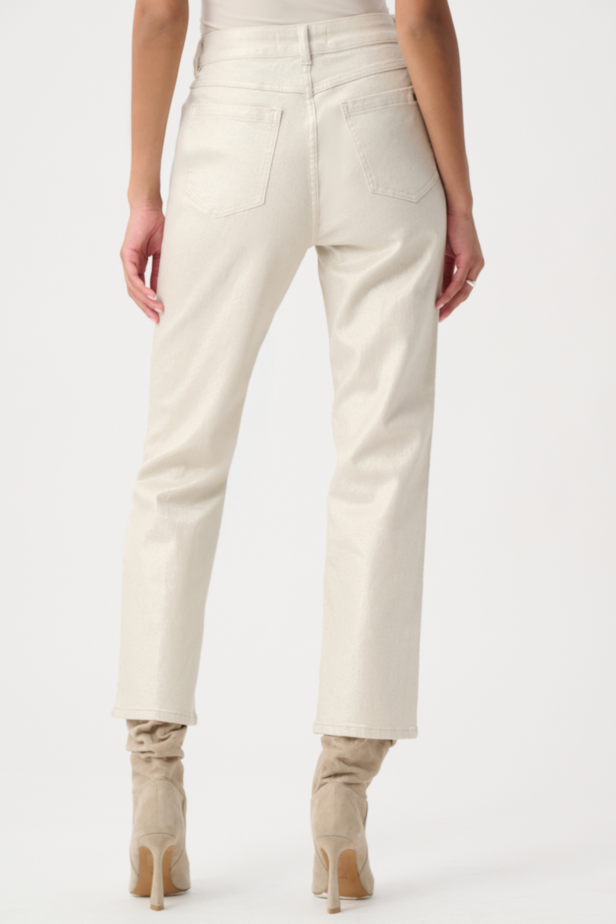 Back view of a model wearing off-white cropped jeans with a straight-leg fit and beige heeled ankle boots against a plain white studio background.
