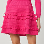 Vibrant pink dress with a sleek, structured silhouette, styled for a festive occasion